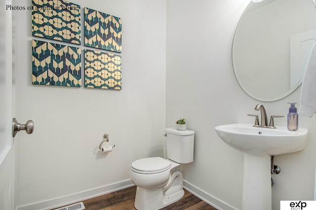 bathroom with hardwood / wood-style flooring and toilet