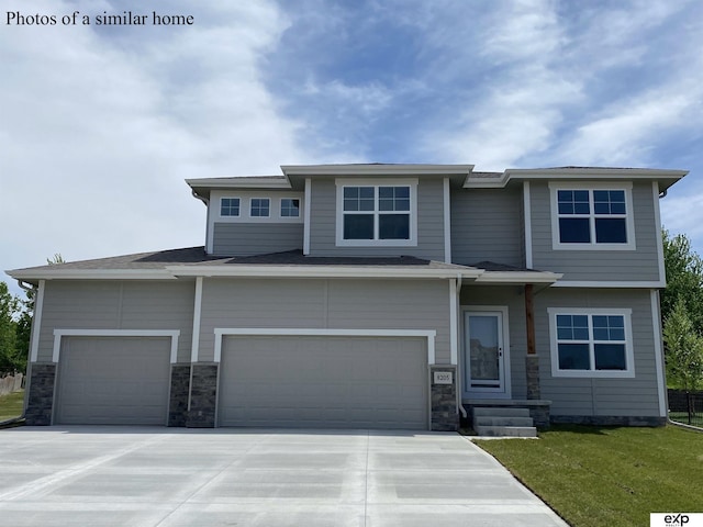 prairie-style house featuring a garage and a front lawn