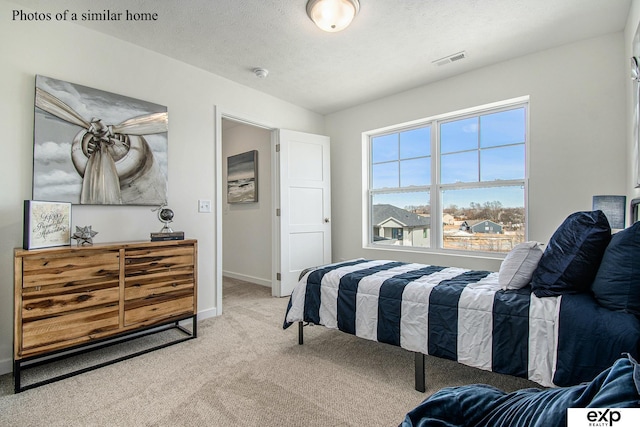 bedroom featuring carpet floors and a textured ceiling