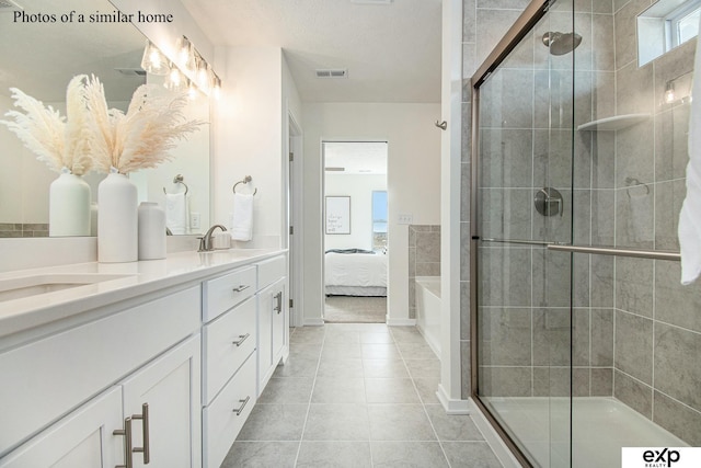 bathroom featuring vanity, a shower with shower door, and tile patterned floors