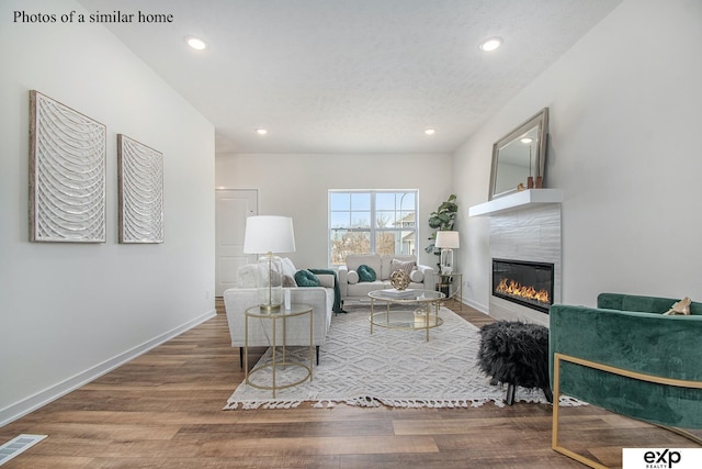 living room featuring hardwood / wood-style flooring and a tiled fireplace