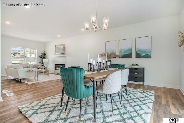 dining space featuring hardwood / wood-style flooring and a chandelier