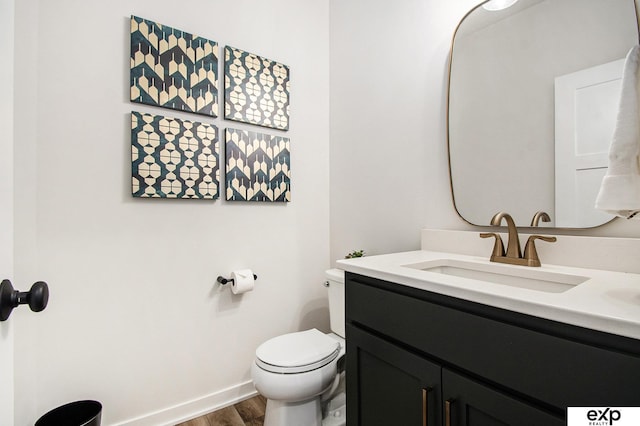 bathroom featuring vanity, wood-type flooring, and toilet