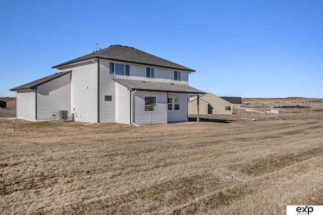 back of house featuring a yard and central AC unit