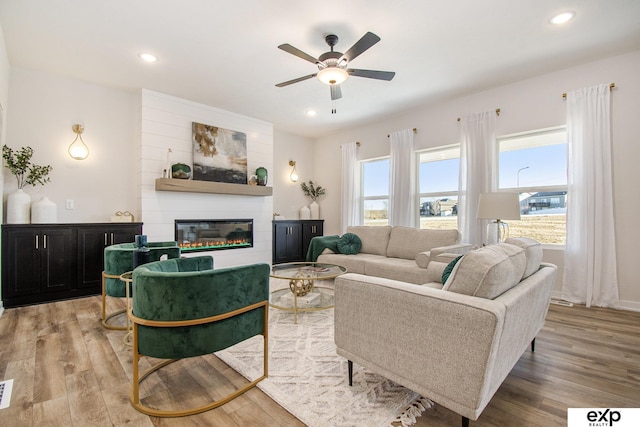 living room featuring ceiling fan and light hardwood / wood-style flooring