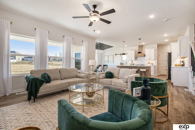 living room with light hardwood / wood-style floors and ceiling fan