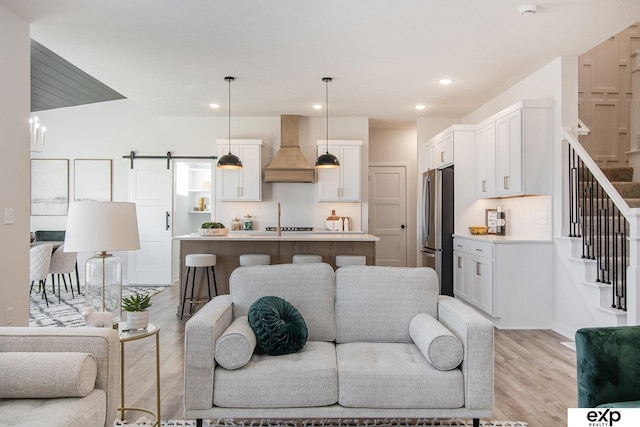 living room featuring a barn door and light hardwood / wood-style flooring