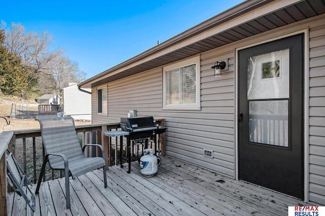 wooden deck featuring a grill