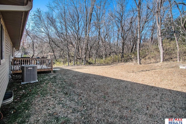 view of yard featuring a deck and central air condition unit