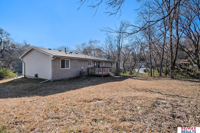 rear view of house featuring a wooden deck, a yard, and cooling unit