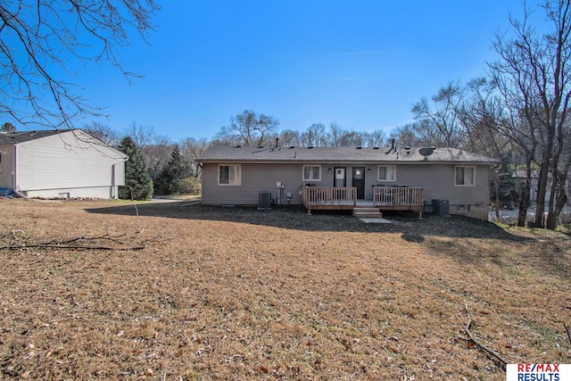 back of house featuring a deck, a lawn, and central air condition unit