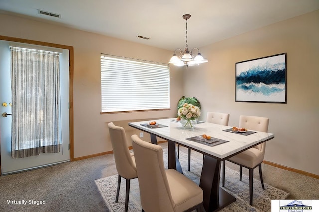 dining space featuring carpet floors and a notable chandelier