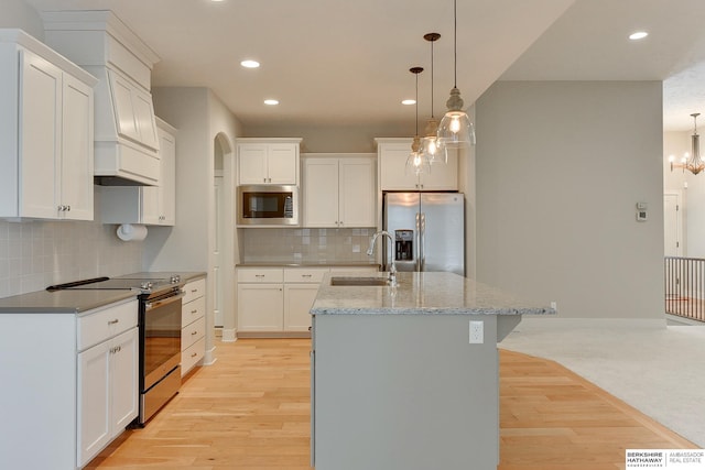 kitchen featuring stainless steel appliances, hanging light fixtures, sink, and white cabinets