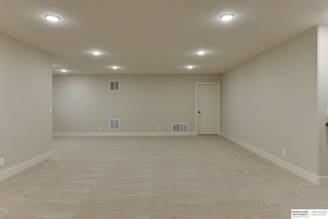 basement with light carpet and a textured ceiling