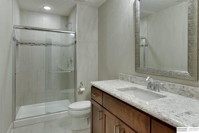 bathroom with an enclosed shower, vanity, a textured ceiling, and toilet