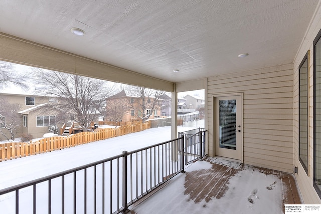 view of snow covered back of property