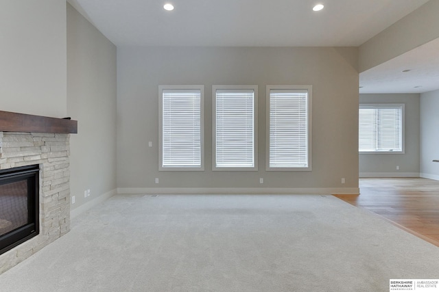 unfurnished living room with light carpet and a fireplace