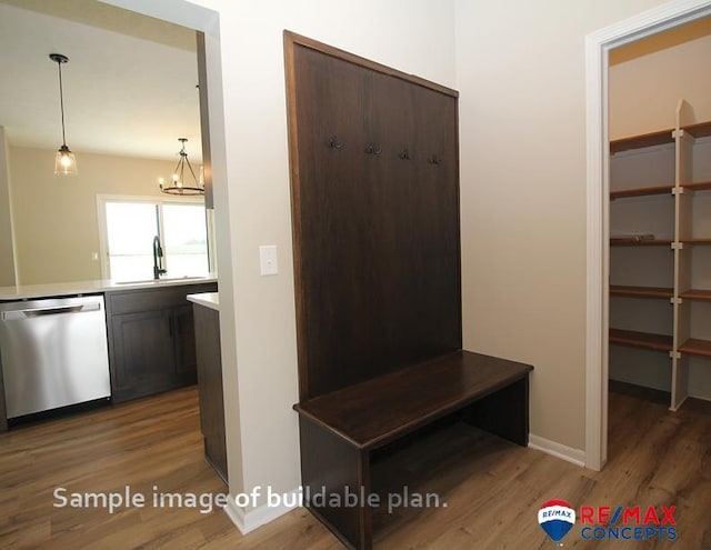 mudroom with baseboards, a chandelier, a sink, and wood finished floors