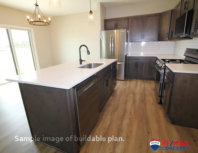 kitchen featuring dark brown cabinets, a sink, appliances with stainless steel finishes, light wood-style floors, and tasteful backsplash