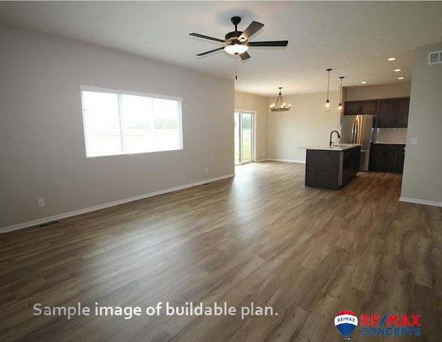 unfurnished living room with baseboards, dark wood-style flooring, ceiling fan with notable chandelier, and recessed lighting
