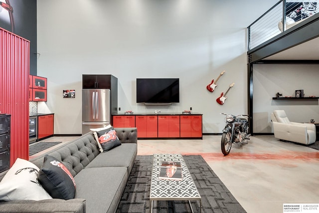 living room featuring wine cooler, a towering ceiling, and sink