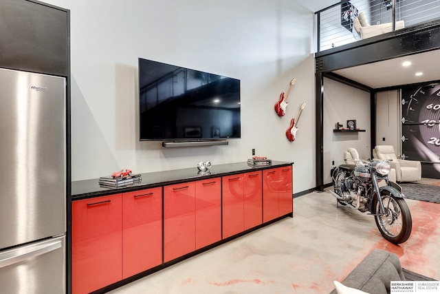 kitchen featuring stainless steel fridge and a high ceiling