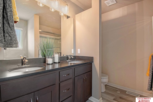 bathroom featuring hardwood / wood-style flooring, vanity, and toilet