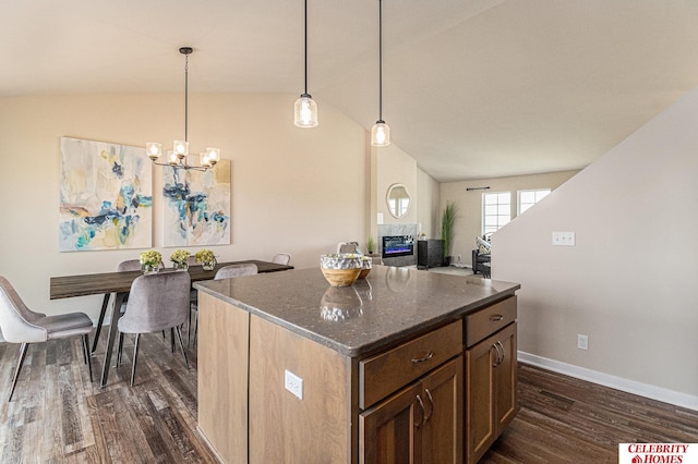 kitchen featuring vaulted ceiling, pendant lighting, a chandelier, dark hardwood / wood-style flooring, and a center island