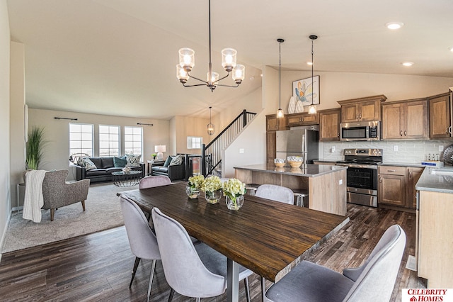 dining space featuring vaulted ceiling, dark hardwood / wood-style floors, and an inviting chandelier