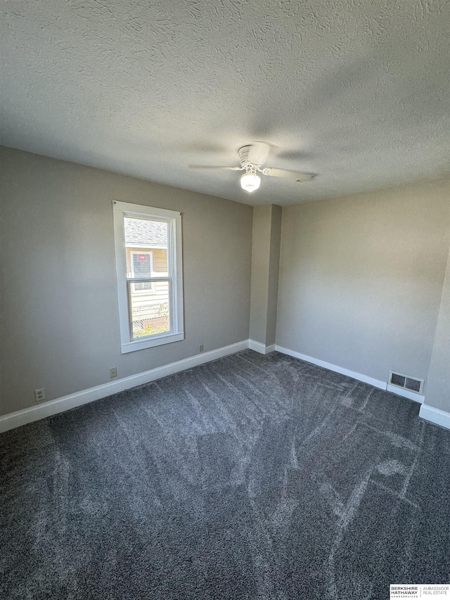 empty room featuring dark carpet, a textured ceiling, and ceiling fan