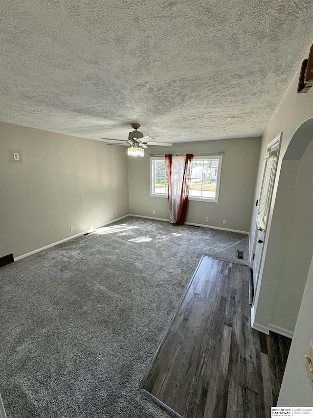 carpeted spare room with ceiling fan and a textured ceiling