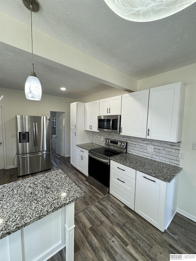 kitchen with white cabinetry, appliances with stainless steel finishes, dark wood-type flooring, and pendant lighting