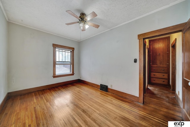 unfurnished room with crown molding, hardwood / wood-style floors, ceiling fan, and a textured ceiling