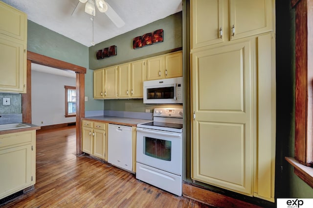 kitchen featuring ceiling fan, white appliances, light hardwood / wood-style floors, and cream cabinets