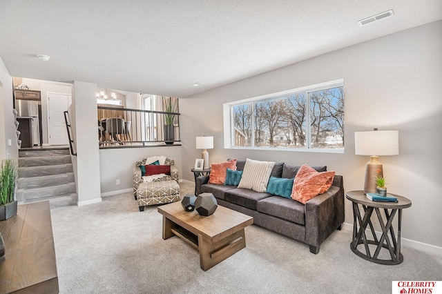 living room featuring light carpet and a chandelier