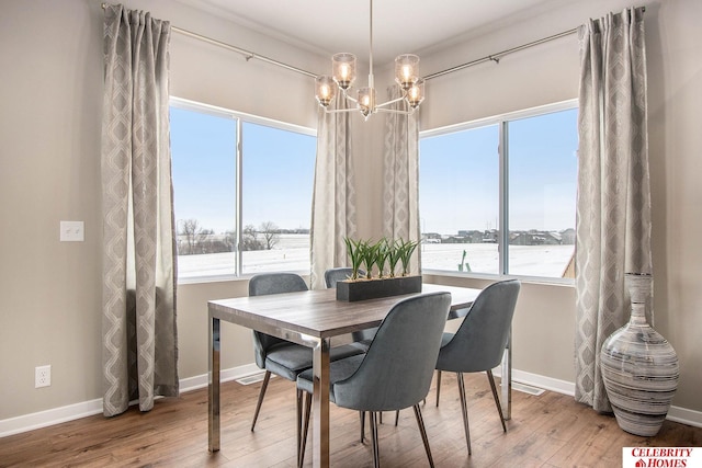 dining area featuring a notable chandelier, wood-type flooring, and a water view