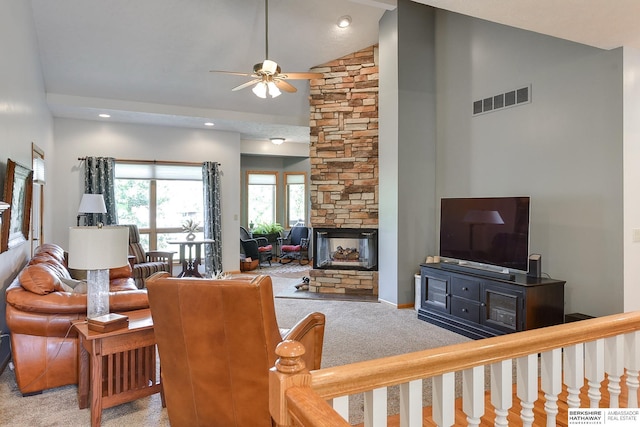 carpeted living room featuring ceiling fan, a stone fireplace, and high vaulted ceiling