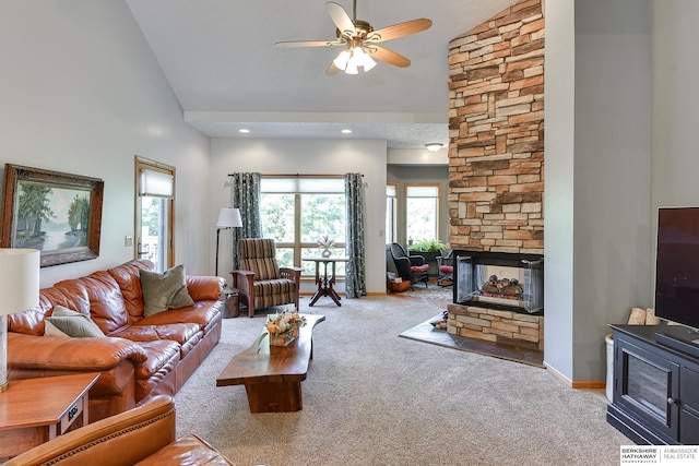 living room with ceiling fan, a fireplace, high vaulted ceiling, and light carpet