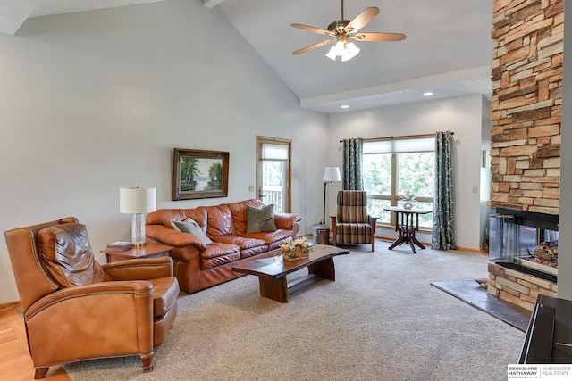 living room featuring ceiling fan, light carpet, a fireplace, and high vaulted ceiling