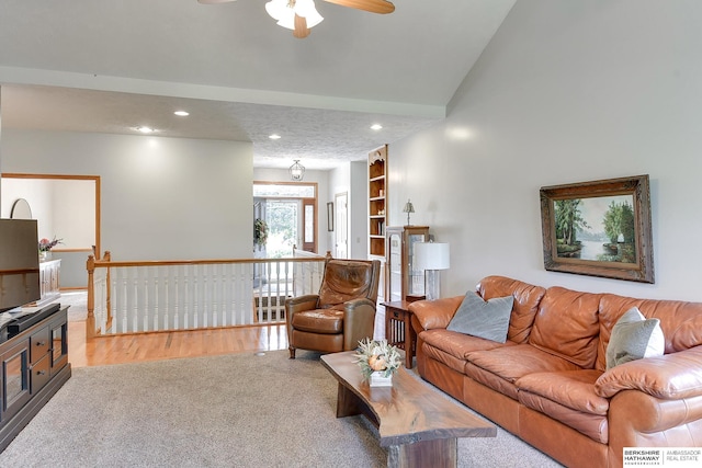 living room with lofted ceiling, a textured ceiling, built in features, and light wood-type flooring