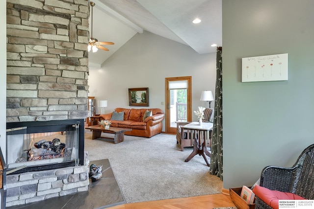 carpeted living room featuring ceiling fan, high vaulted ceiling, a fireplace, and beam ceiling