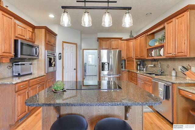 kitchen with appliances with stainless steel finishes, a kitchen breakfast bar, and a kitchen island