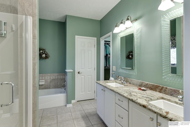 bathroom featuring tile patterned flooring, vanity, and shower with separate bathtub