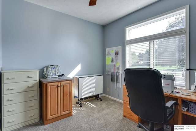 carpeted home office featuring ceiling fan