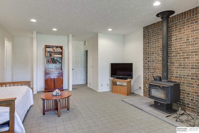 carpeted living room with a textured ceiling and a wood stove