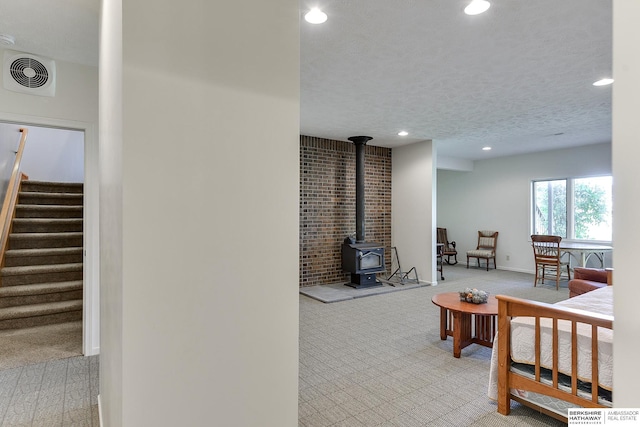 living room featuring a textured ceiling and a wood stove