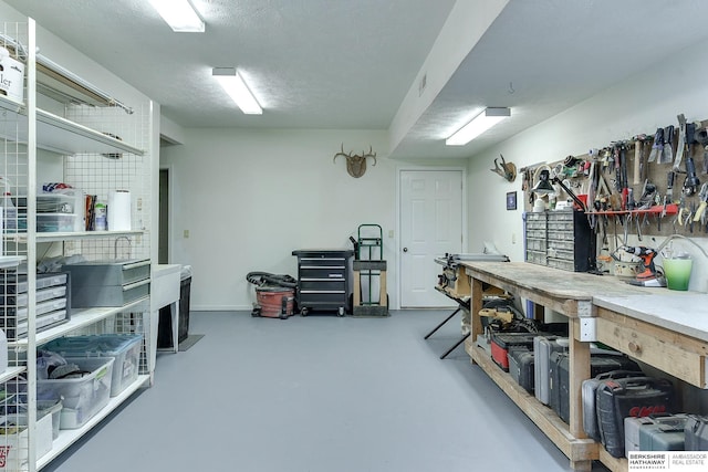 interior space featuring concrete floors, a textured ceiling, and a workshop area