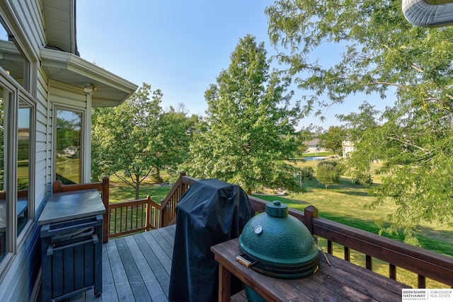 wooden deck featuring a lawn