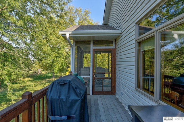 wooden deck featuring a sunroom and grilling area