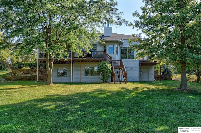 rear view of house with a wooden deck and a lawn